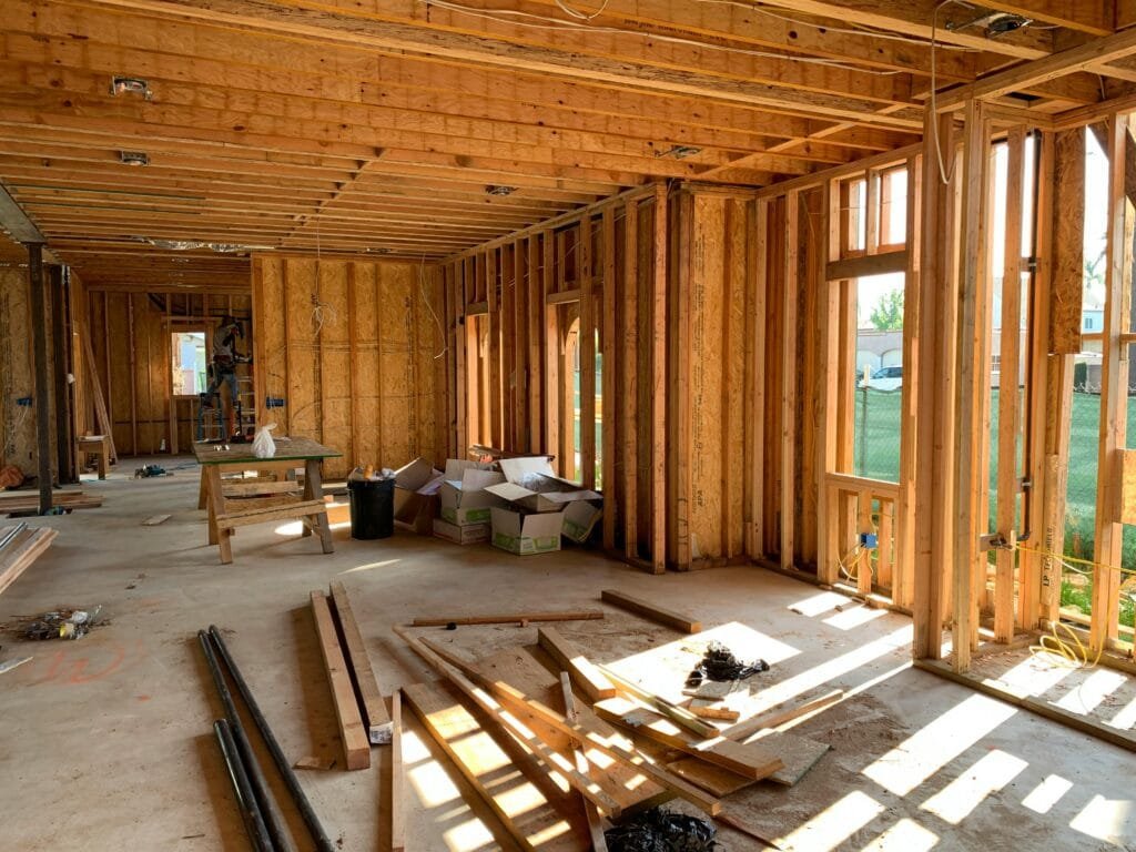 Sunlit interior with wood framing, showcasing home construction progress.